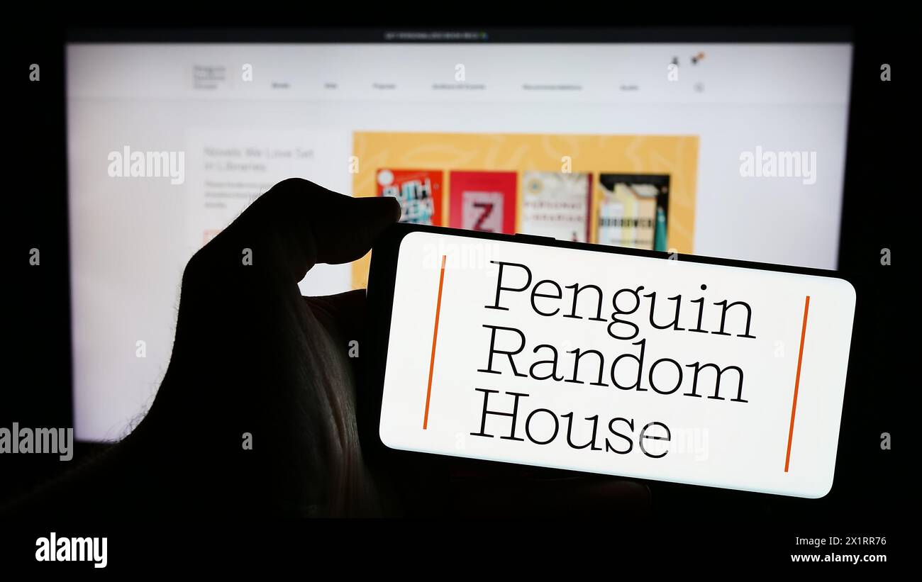 Persona che possiede un telefono cellulare con il logo della casa editrice americana Penguin Random House di fronte alla pagina web aziendale. Mettere a fuoco il display del telefono. Foto Stock