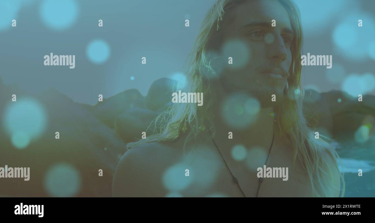Giovane adulto caucasico in piedi con un look premuroso, luce che si riflette intorno Foto Stock
