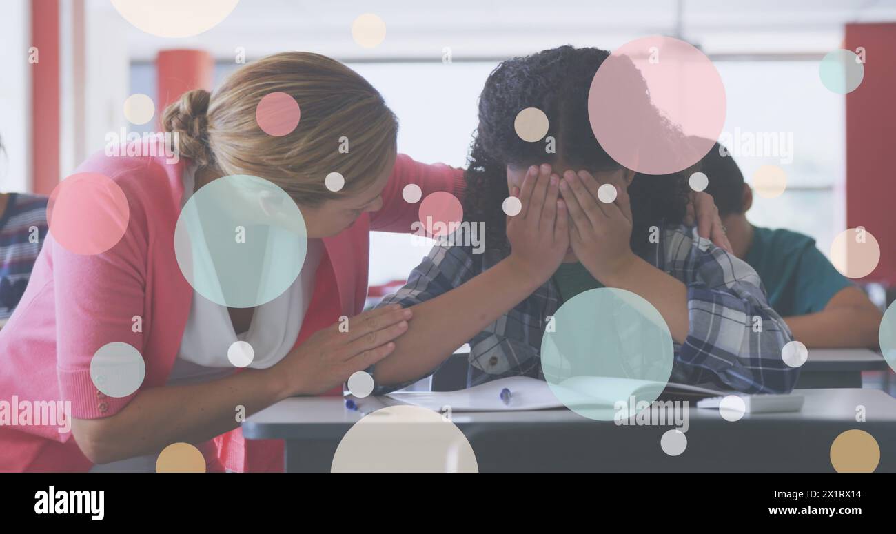 A scuola, un insegnante caucasico di mezza età conforta un giovane studente mediorientale Foto Stock
