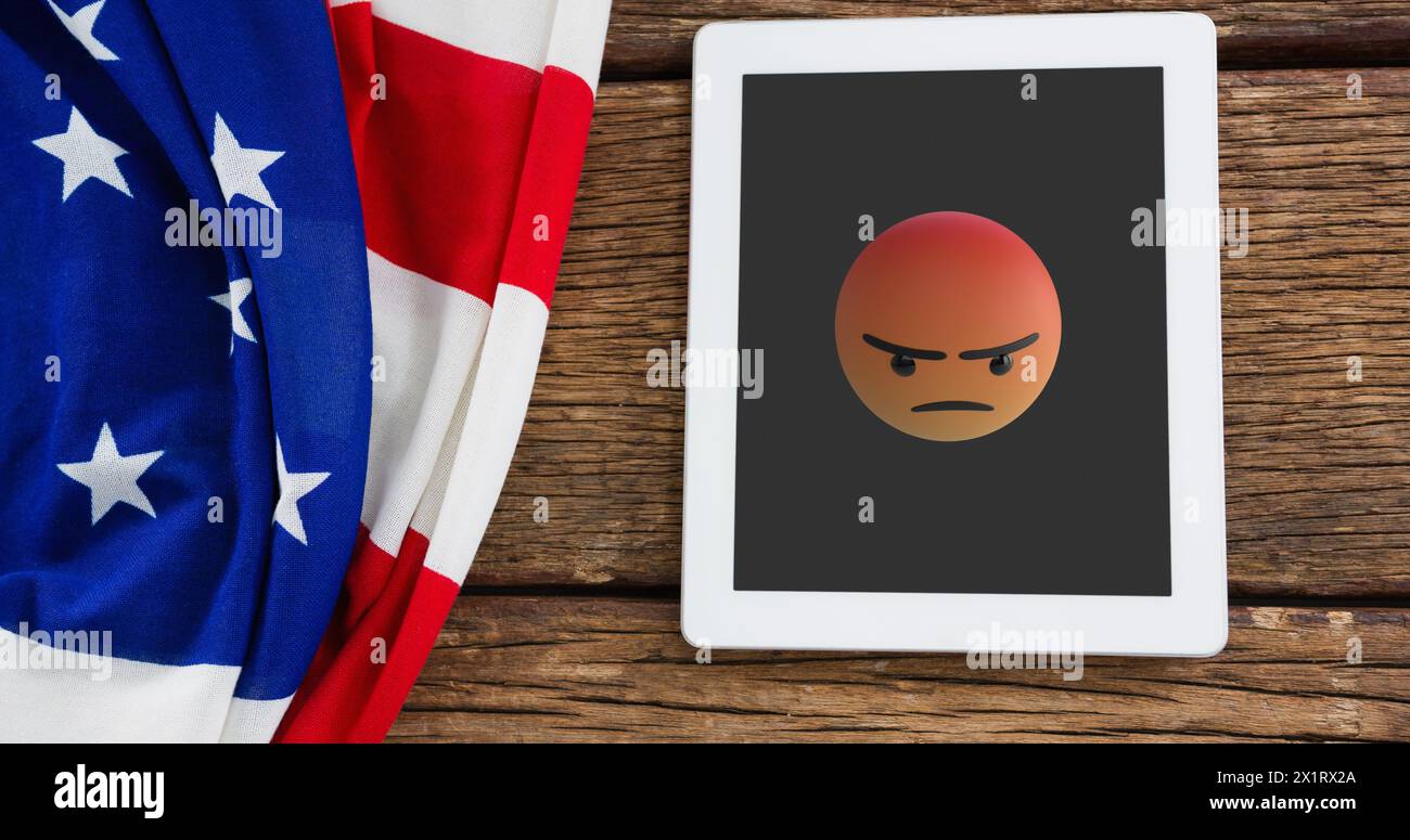 Una tavoletta con un'emoji arrabbiata si trova accanto a una bandiera americana Foto Stock