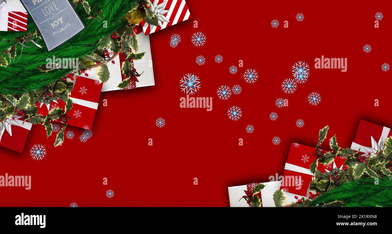 Scena festiva: Sfondo rosso, fiocchi di neve, buoni regalo, verde, decorazioni Foto Stock