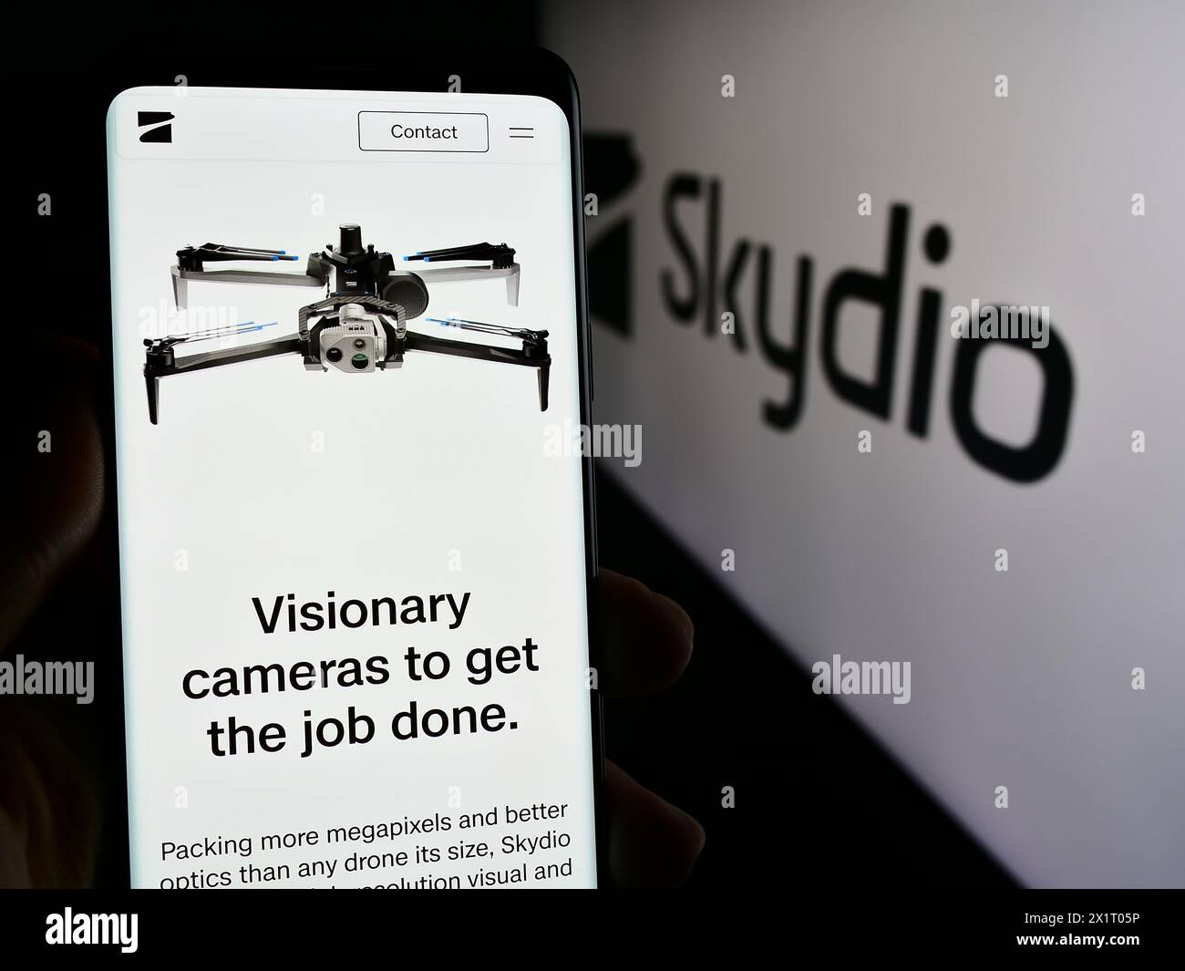 Persona che possiede un telefono cellulare con pagina Web della società di produzione di droni Skydio Inc. Davanti al logo. Messa a fuoco al centro del display del telefono. Foto Stock