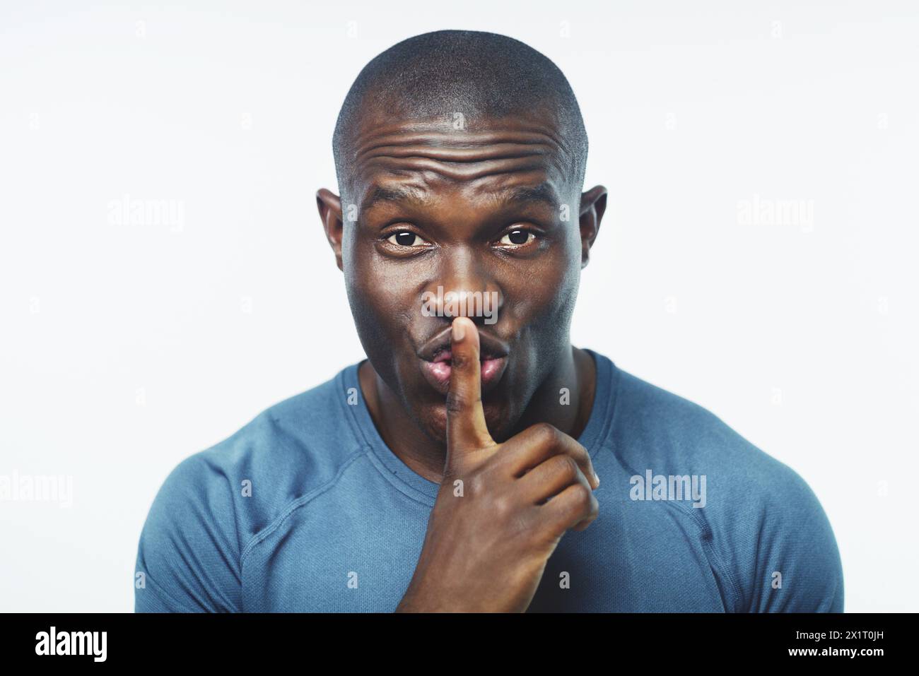 Uomo nero, ritratto e fitness con segreto per allenamento, routine o privacy su uno sfondo bianco. Faccia di persona africana o maschile con silenzio Foto Stock