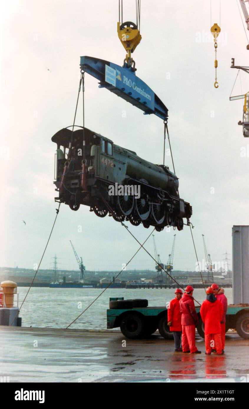 Locomotiva a vapore Flying Scotsman scaricata dalla nave container francese CGM la Perouse presso Tilbury Docks, al ritorno dall'Australia. La loco aveva viaggiato per il paese mentre prendeva parte alle celebrazioni del bicentenario australiano nel 1988. LNER Classe A3 4472 Flying Scotsman appeso al gancio della gru Foto Stock