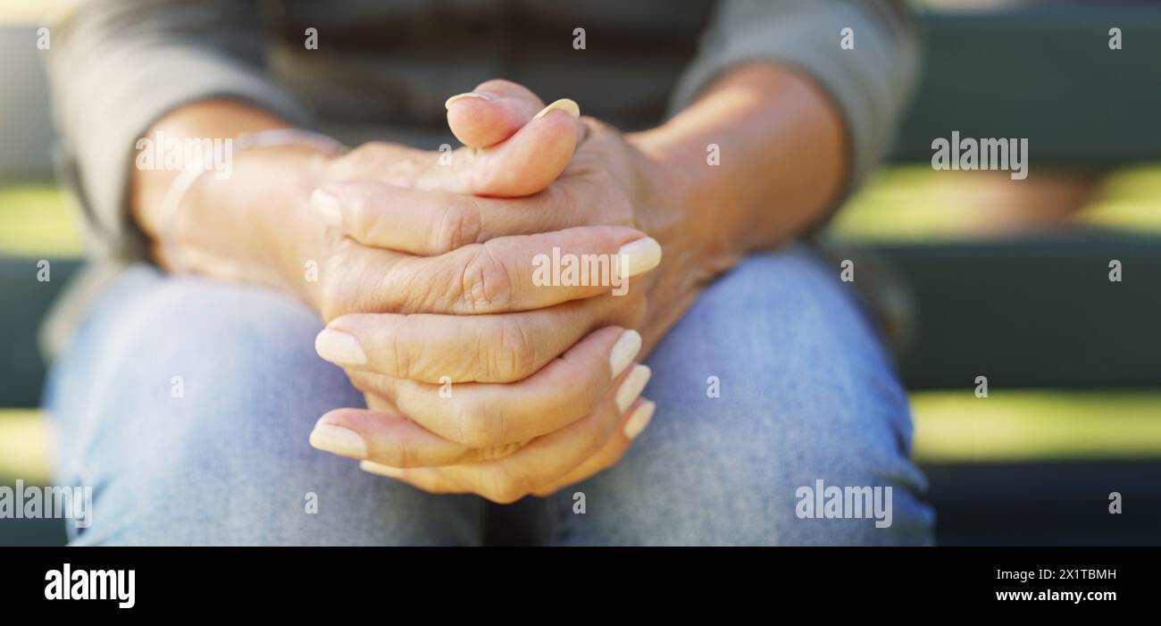 Mani, nervoso e preoccupazione con una persona che pensa all'aperto sulla panchina per ansia, depressione o stress. Salute mentale, preghiera e benessere con adulto Foto Stock