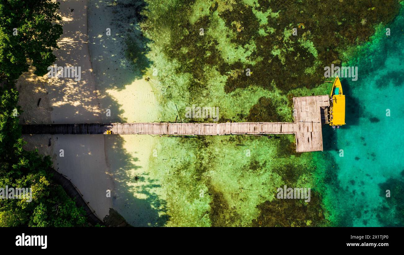 Drone, isola tropicale e barca all'aperto, attracco e natura viaggiano per l'avventura del pianeta. Vista aerea, Raja Ampat e la giungla in Indonesia per le vacanze Foto Stock