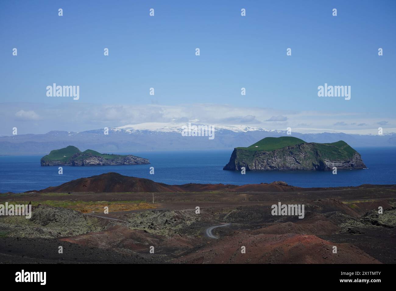 Vista delle isole Elliðaey e Bjarnarey dalla cima del vulcano Eldfell, le isole Westman. Sullo sfondo, i ghiacciai Mýrdalsjökull e Eyjafjallaj Foto Stock