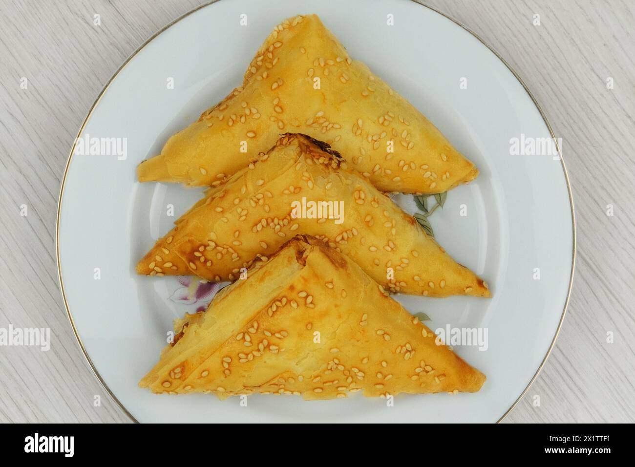 Cucina orientale. Samosas in un piatto su sfondo bianco. Cibo fatto in casa. Fast food. Vista dall'alto. Foto Stock