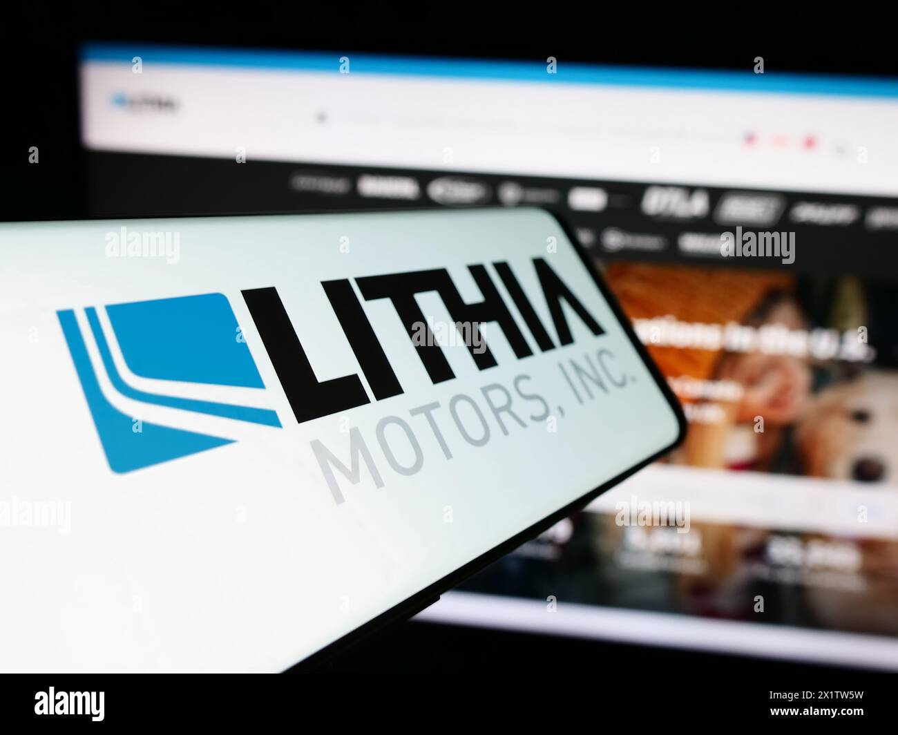 Telefono cellulare con logo della concessionaria automobilistica americana Lithia Motors Inc. Davanti al sito Web. Mettere a fuoco la parte centrale sinistra del display del telefono. Foto Stock