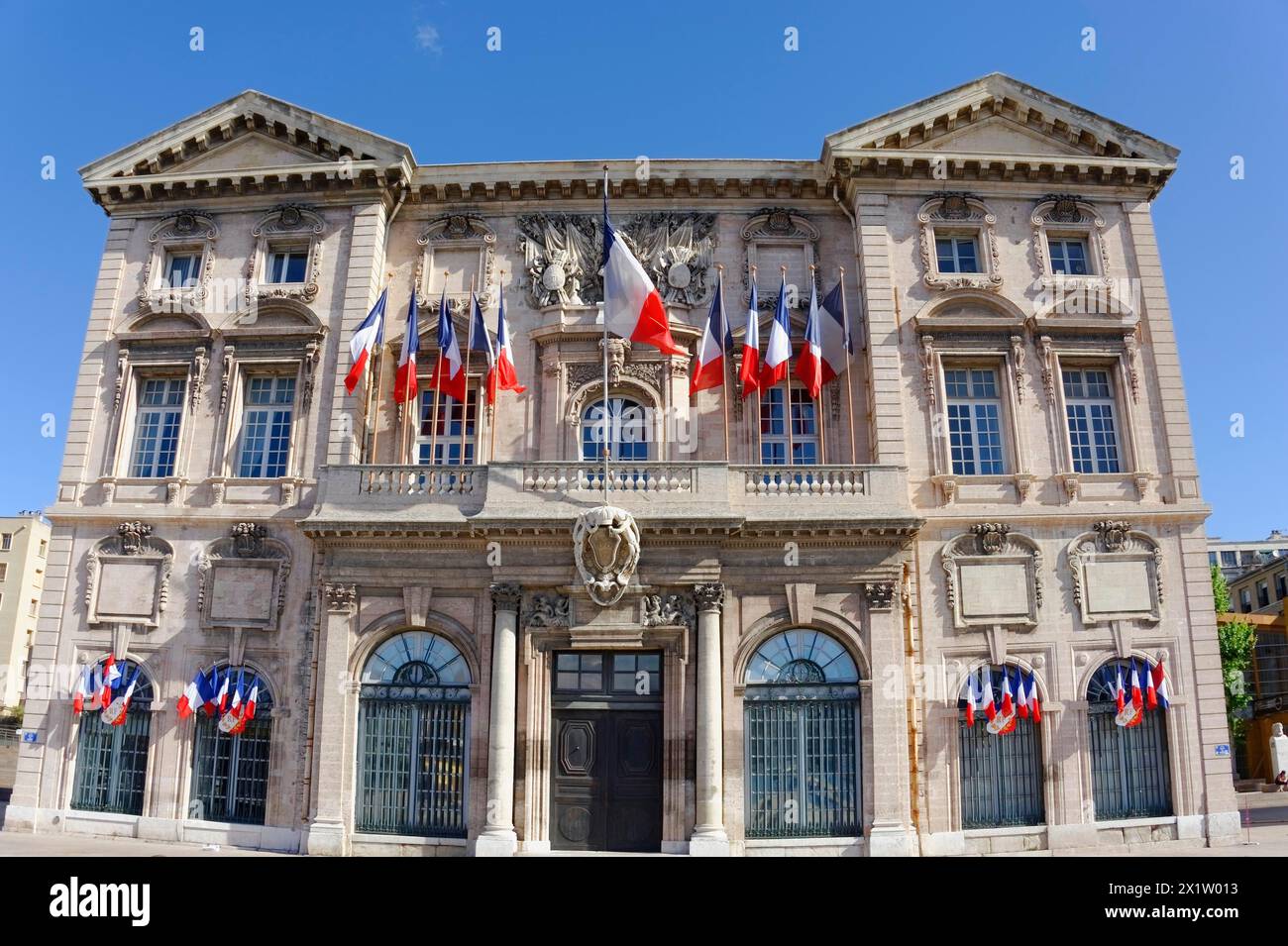 Vecchio Municipio, Hotel de Ville, nel Porto Vecchio di Marsiglia, imponente edificio del municipio decorato con bandiere sotto un cielo blu, Marsiglia Foto Stock