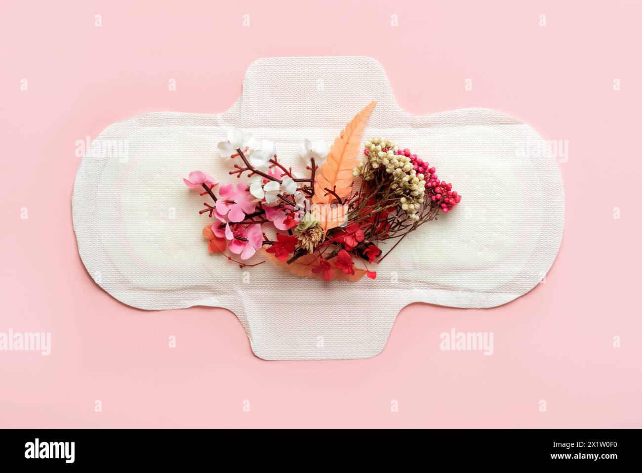 Vista dall'alto dei tamponi sanitari e dei mazzi di fiori su sfondo rosa. Concetto di mestruazione Foto Stock