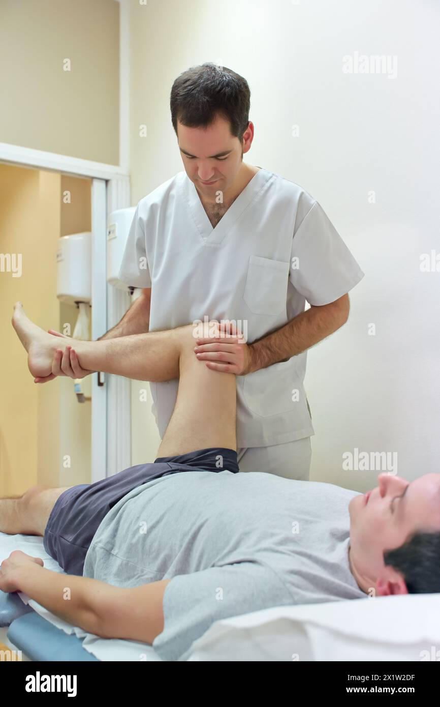 Mobilizzazione rotazione esterna dell'anca passiva per vincere l'arco articolare Centro medico di fisioterapia, Donostia, San Sebastian, Gipuzkoa, Paesi Baschi, Spagna. Foto Stock