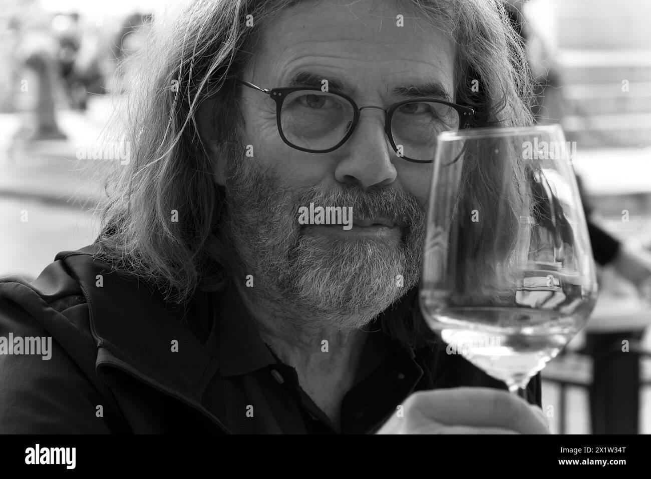 Ritratto di un uomo con barba e bicchieri, brinda con un bicchiere di vino, Genova, Italia Foto Stock