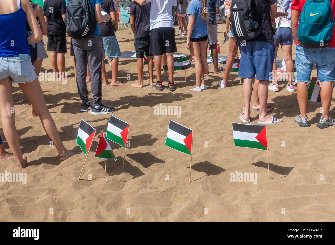 Gran Canaria, Isole Canarie, Spagna, 18 aprile 2024. Studenti che detengono bandiere della Palestina al raduno pro Gaza sulla spiaggia della città di Las Palmas sotto striscioni che dicono di fermare il genocidio e la pace in Palestina, no all'apartheid israeliano credito: Alan Dawson/Alamy Live News. Foto Stock