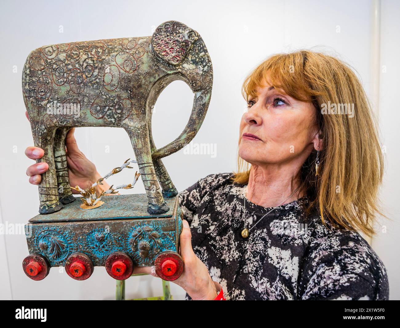 Londra, Regno Unito. 18 aprile 2024. Elephant Pulling Angels Out of Pandora's Box di Louise Bell - Ceramic Art London - oltre 110 produttori provenienti da tutto il mondo espongono alla fiera che celebra i suoi 20 anni con il trasferimento nella sede più grande di Olympia a West London. Crediti: Guy Bell/Alamy Live News Foto Stock