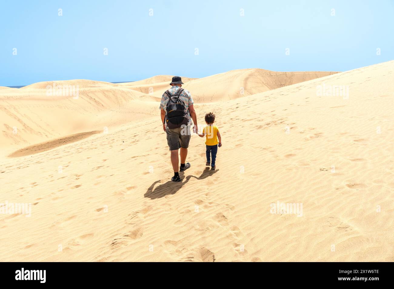 Padre e figlio in vacanza sorridenti tra le dune di Maspalomas, Gran Canaria, Isole Canarie Foto Stock