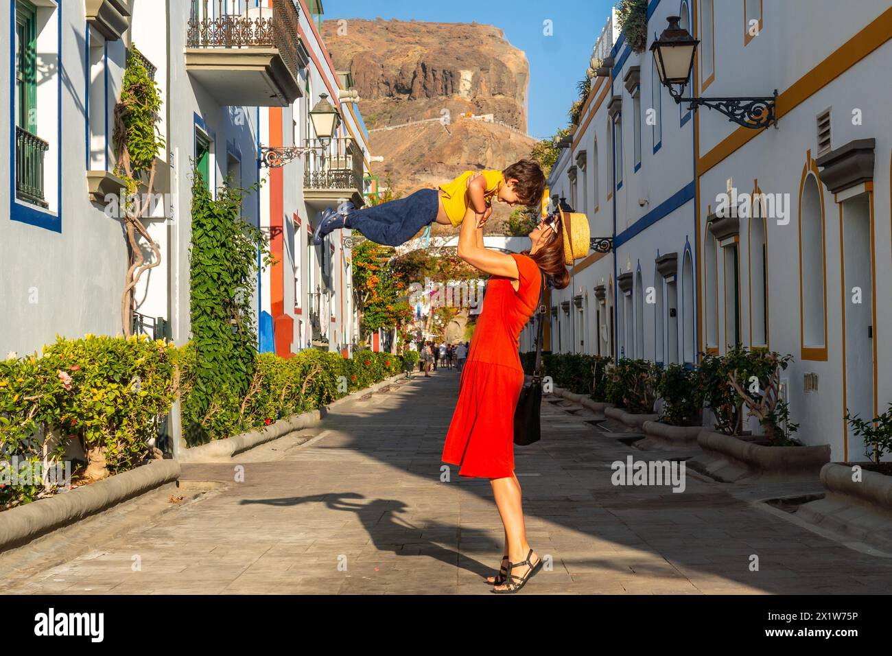 Madre che si diverte con il figlio cresciuto nel porto della città di Mogan a Gran Canaria. Vacanza in famiglia Foto Stock