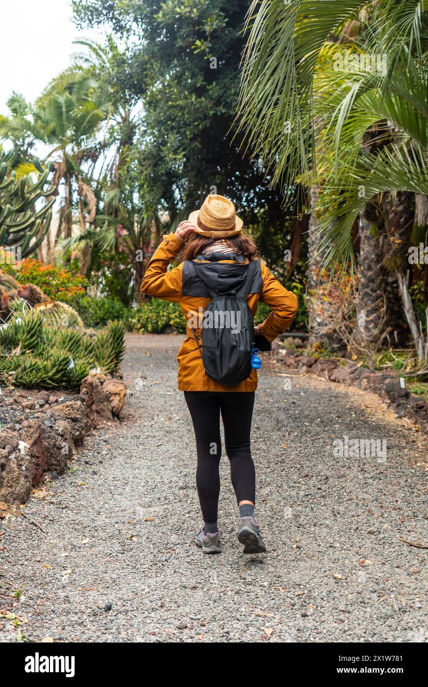 Una donna turistica che cammina in un giardino botanico. Concetto di piante tropicali Foto Stock