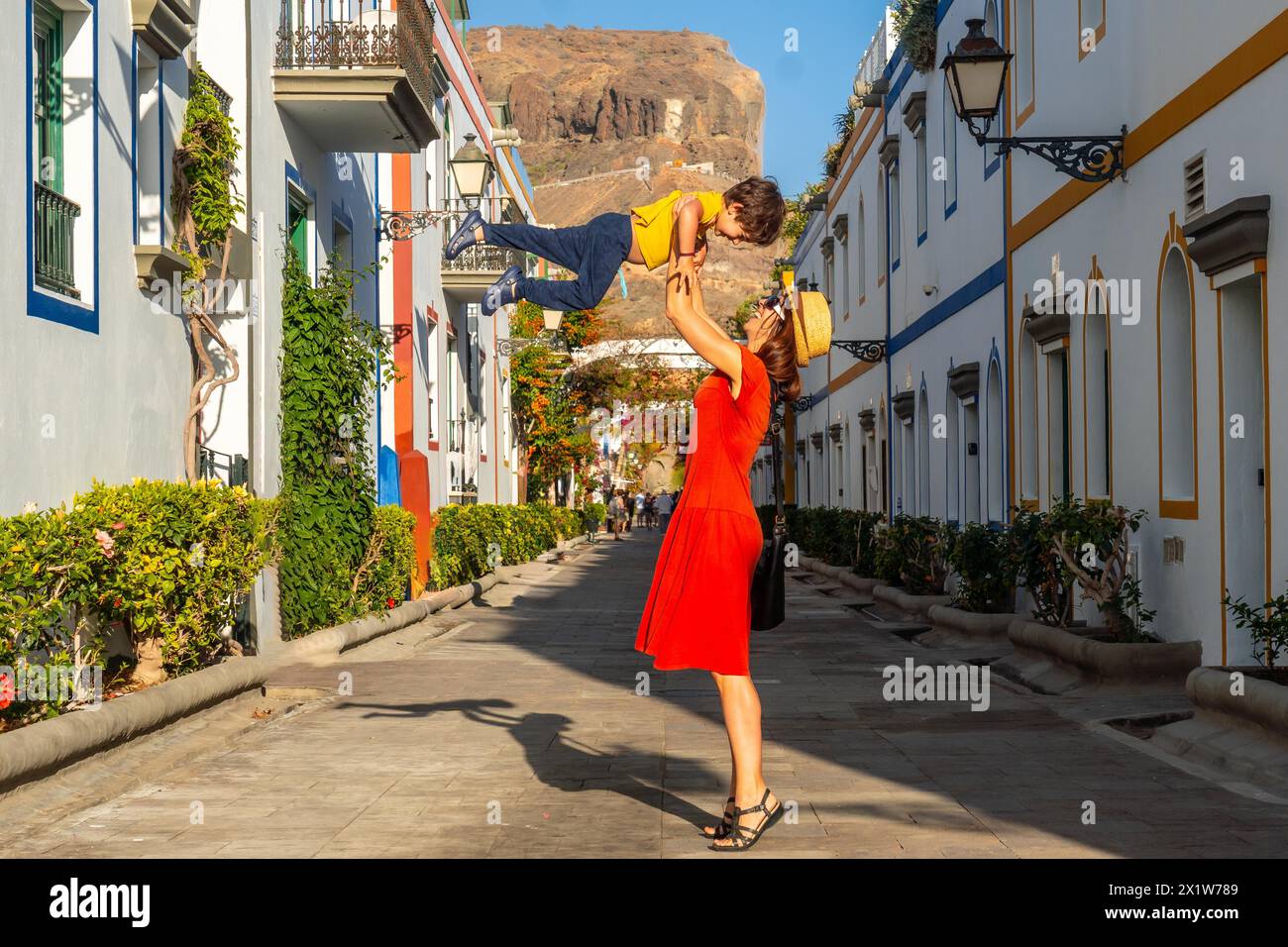 Madre che si diverte con il figlio cresciuto nel porto della città di Mogan a Gran Canaria. Vacanza in famiglia Foto Stock