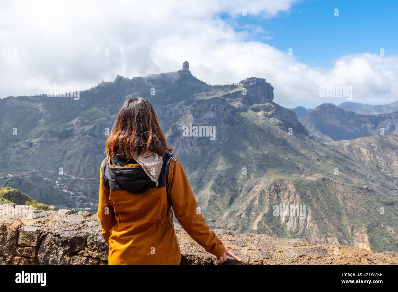 Una donna turistica che guarda Roque Nublo da un punto di vista sulla montagna. Gran Canaria, Spagna Foto Stock