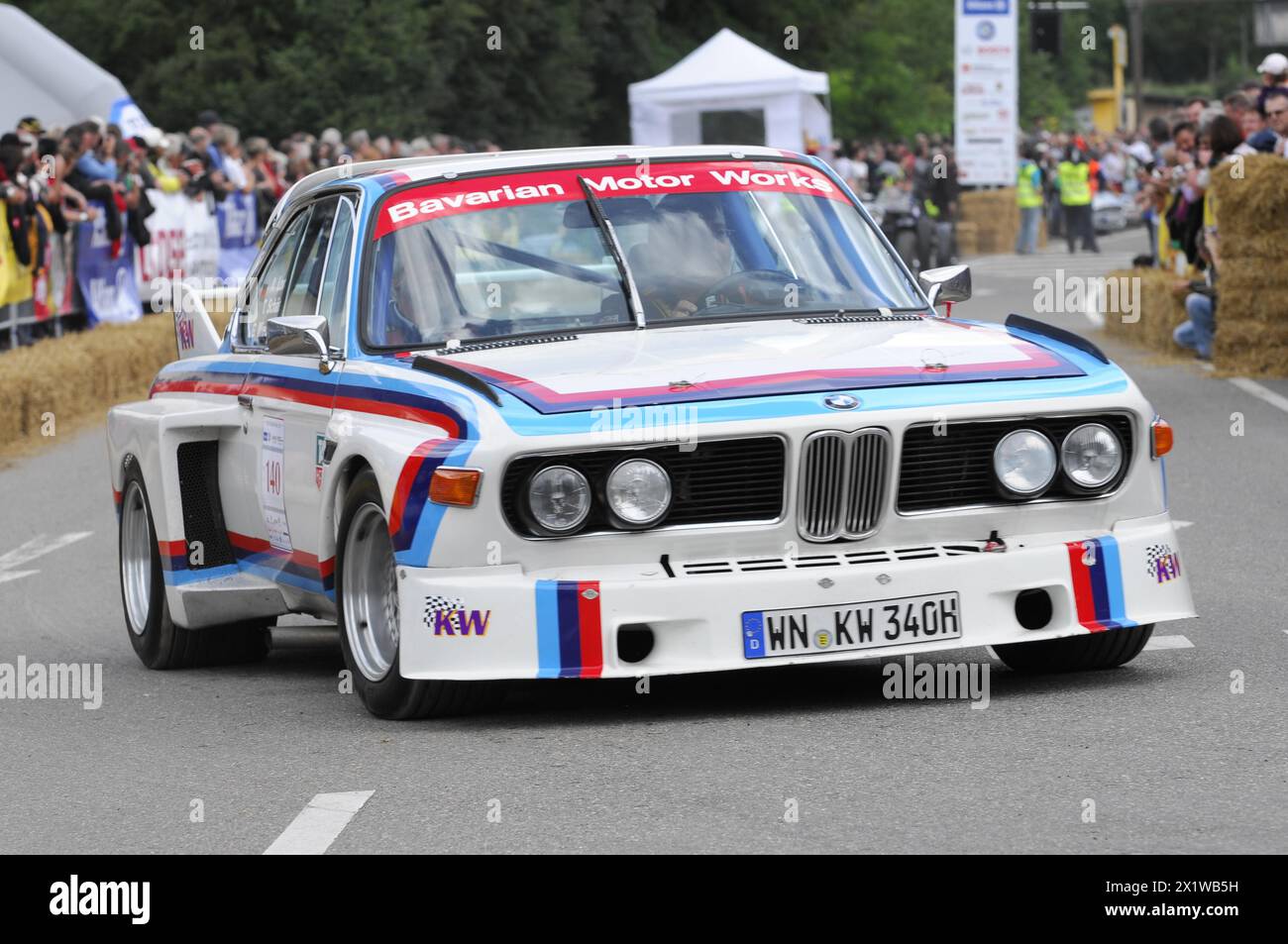 Una classica auto da corsa BMW in livrea bianca, blu e rossa passa davanti agli spettatori, SOLITUDE REVIVAL 2011, Stoccarda, Baden-Wuerttemberg, Germania Foto Stock