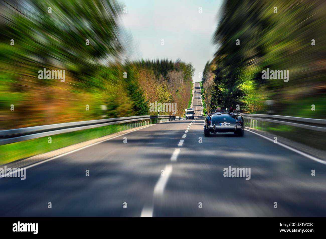 Effetto zoom, strada di campagna vicino a Boerwang con vecchia auto sportiva MG, Allgaeu, Svevia, Baviera, Germania Foto Stock