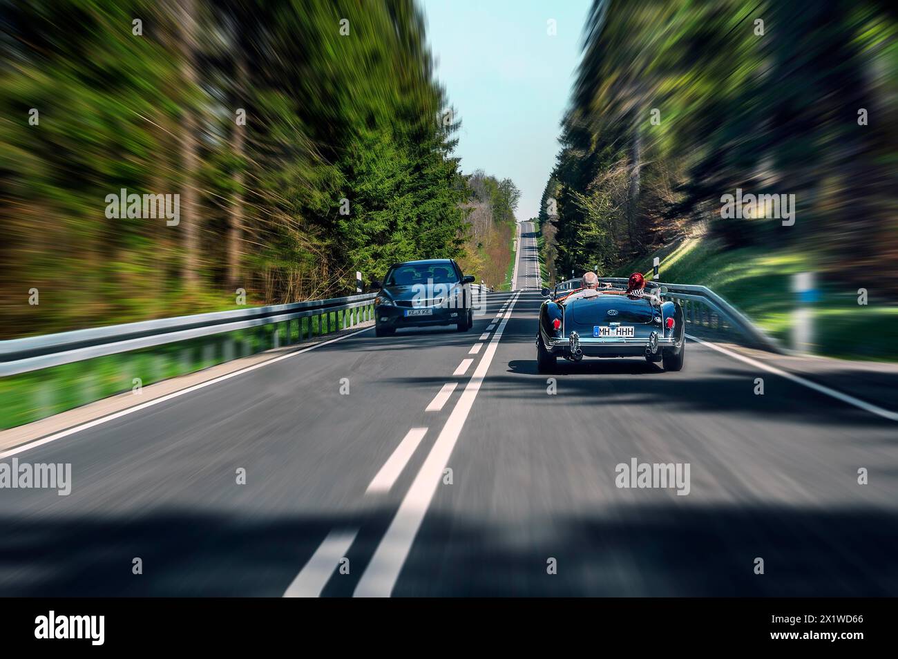 Effetto zoom, strada di campagna vicino a Boerwang con vecchia auto sportiva MG, Allgaeu, Svevia, Baviera, Germania Foto Stock