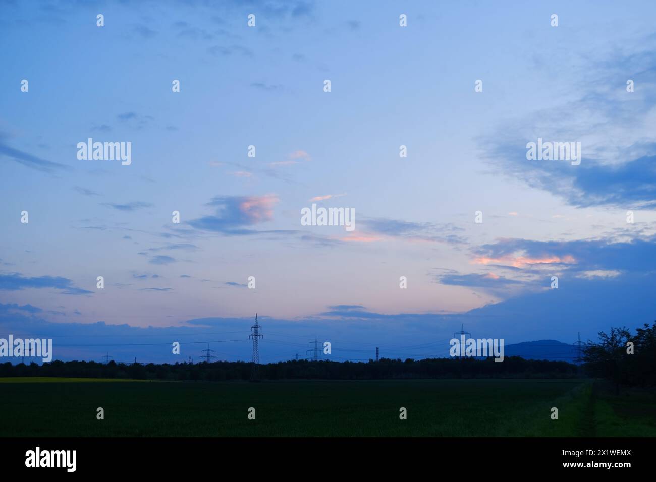 Spettacolare tramonto, cielo rosa e viola con sfumature, nuvole scure, trascendenza concettuale, cambiamento stagionale delle condizioni meteorologiche, serata idilliaca, Heave Foto Stock