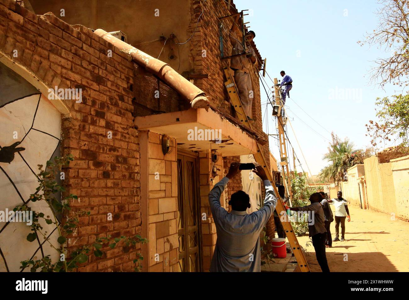 (240418) -- OMDURMAN, 18 aprile 2024 (Xinhua) -- questa foto scattata con un telefono cellulare il 17 aprile 2024 mostra volontari che riparano impianti di alimentazione danneggiati a Omdurman, Sudan. Il conflitto armato tra le forze armate sudanesi (SAF) e le forze paramilitari di supporto rapido (RSF) è entrato nel suo secondo anno. Da quando il conflitto è scoppiato il 15 aprile 2023, sono stati registrati più di 14.700 morti, mentre il numero di sfollati all'interno e all'esterno del Sudan ha raggiunto i 8,2 milioni, ha dimostrato una recente relazione dell'Ufficio delle Nazioni Unite per il coordinamento delle questioni umanitarie Foto Stock