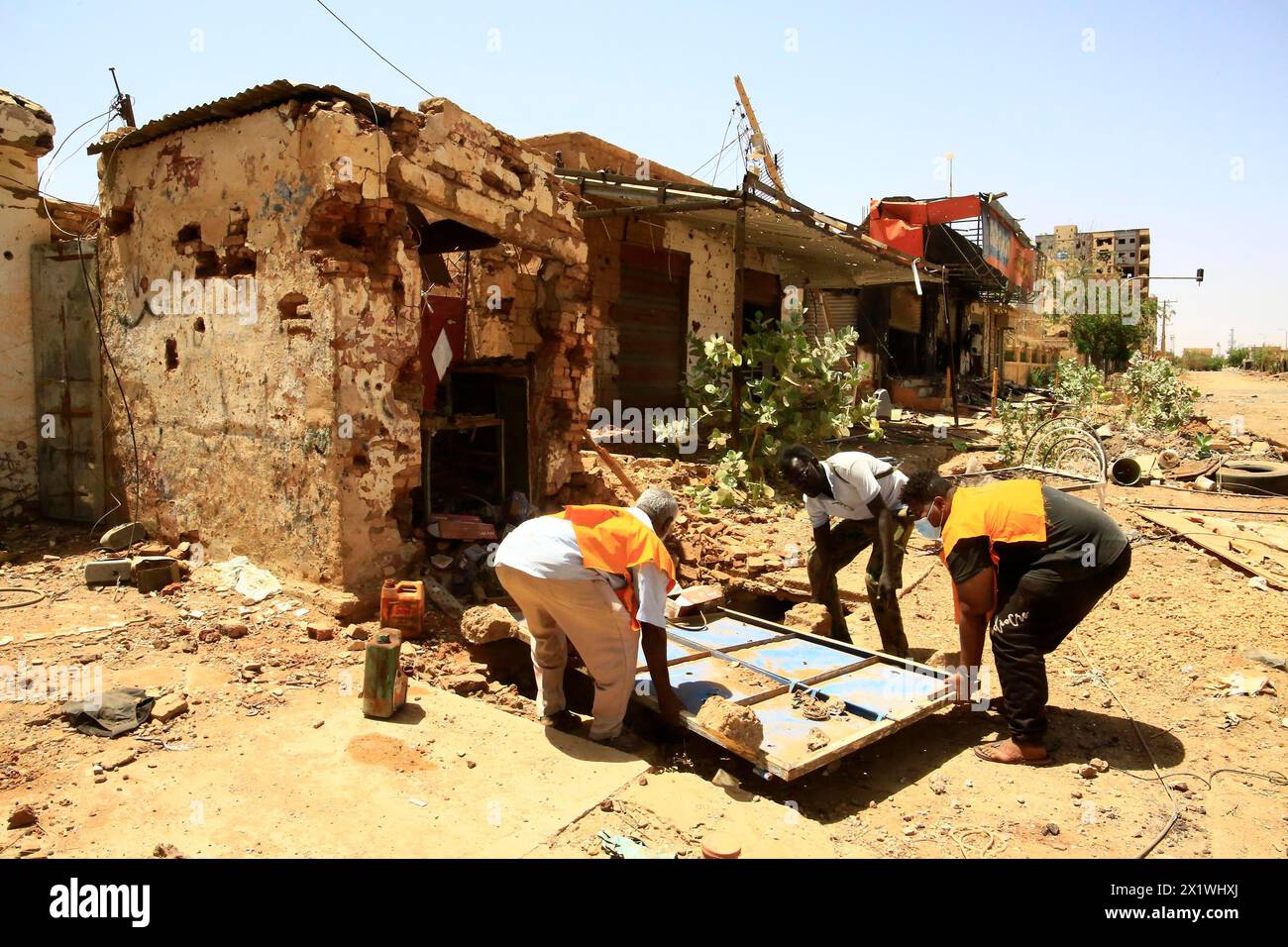 (240418) -- OMDURMAN, 18 aprile 2024 (Xinhua) -- questa foto scattata con un cellulare il 17 aprile 2024 mostra volontari che puliscono una casa danneggiata a Omdurman, Sudan. Il conflitto armato tra le forze armate sudanesi (SAF) e le forze paramilitari di supporto rapido (RSF) è entrato nel suo secondo anno. Da quando il conflitto è scoppiato il 15 aprile 2023, sono stati registrati più di 14.700 morti, mentre il numero di sfollati all'interno e all'esterno del Sudan ha raggiunto i 8,2 milioni, come dimostra una recente relazione dell'Ufficio delle Nazioni Unite per il coordinamento degli affari umanitari. (Foto di Moha Foto Stock