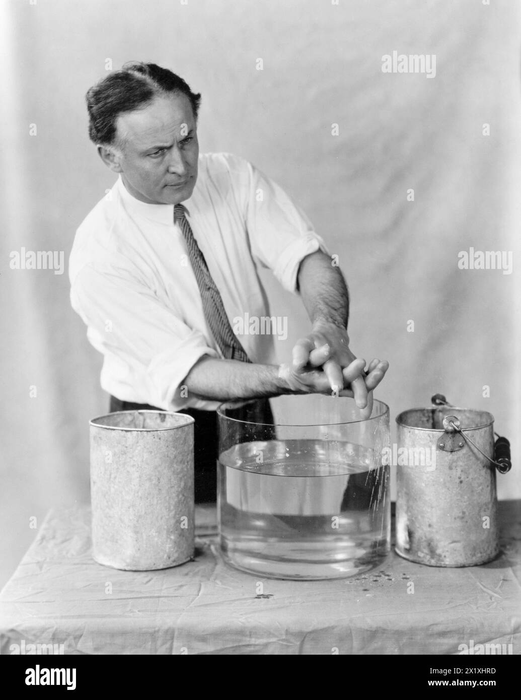 Harry Houdini realizza mani spirituali - 1923 - in questa sequenza di fotografie Houdini ha dimostrato come le mani spiritose apparse alle sedute fossero fatte da esseri meno eterei. In "Un mago tra gli spiriti" Houdini descrisse la frode mediumistica nota come "impronte digitali di uno spirito". Una sagoma della mano di un morto sarebbe stata accuratamente preparata e, durante una seduta con i parenti creduti, le impronte digitali del defunto apparivano su una tromba nera di lampione. Nel suo libro Houdini ha dichiarato quanto segue: "Ci sono due casi registrati in cui le fortune erano in gioco a causa di questo tipo di frode. In uno Foto Stock