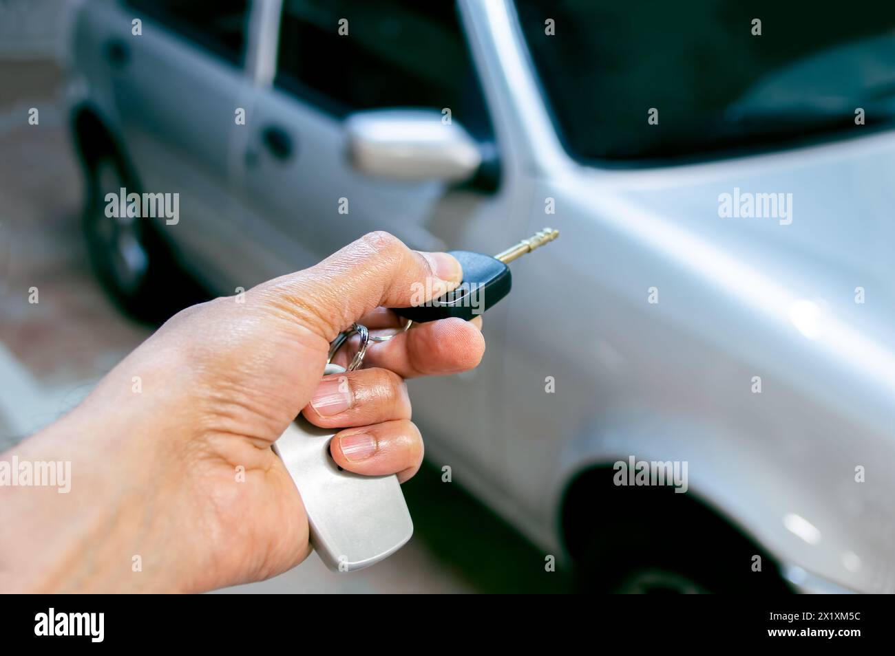 Scatto di una mano di un uomo premere i sistemi di allarme per auto con telecomando Foto Stock