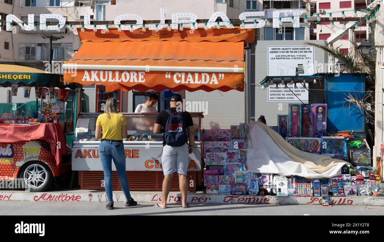 Foto di due persone che acquistano un gelato in un piccolo negozio vicino alla strada lungo il lungomare. Foto Stock