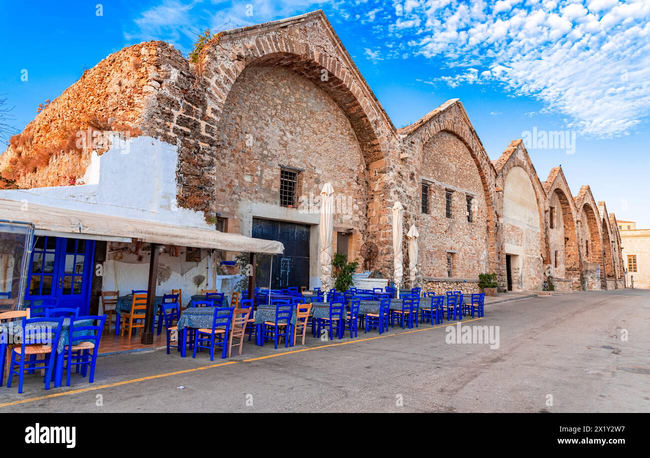 Arsenali di Chania, Creta, Grecia: Taverna tradizionale sulla strada dei vecchi cantieri navali veneziani, vecchio porto di Chania in una soleggiata mattinata d'estate Foto Stock
