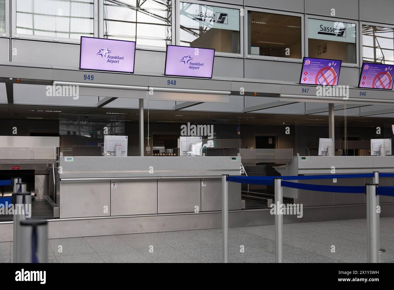 Aeroporto internazionale di Francoforte, Germania - 19 febbraio 2024: Display con l'annuncio dell'aeroporto di Francoforte appesi al di sopra del conteggio dei check-in vuoti Foto Stock