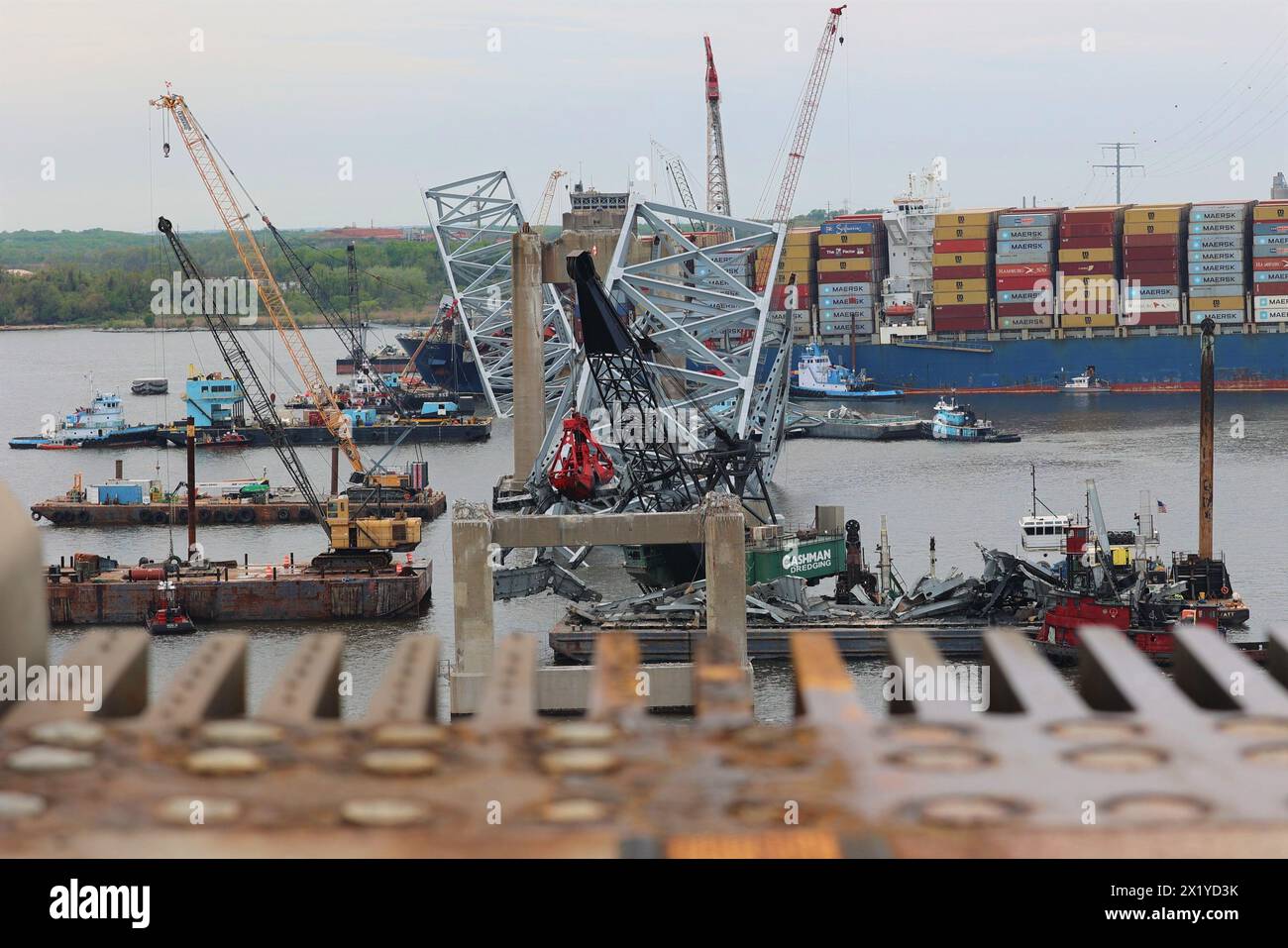 I salvatori continuano a rimuovere i detriti dal sito di rottami del Francis Scott Key Bridge, visto dal bordo del ponte rimanente che rimane ancora in piedi il 17 aprile. La rimozione di detriti e rottami è in corso a sostegno di una priorità assoluta per aprire in modo sicuro ed efficiente il canale di Fort McHenry. Foto Stock