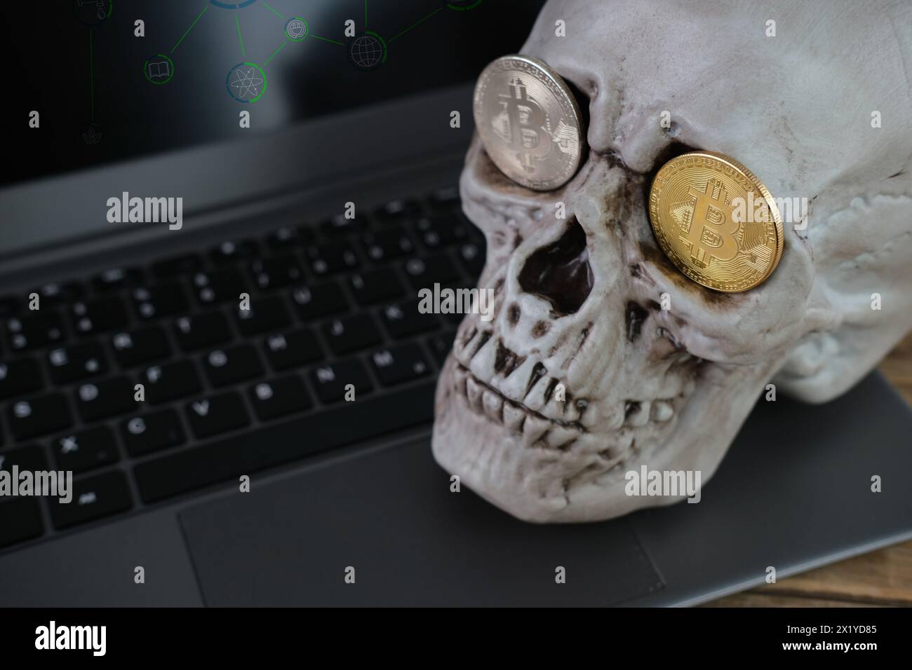 teschio umano su una tastiera portatile, bitcoin metallici nelle prese degli occhi, il concetto di mining di criptovaluta, la transitorietà della vita, l'inevitabilità Foto Stock
