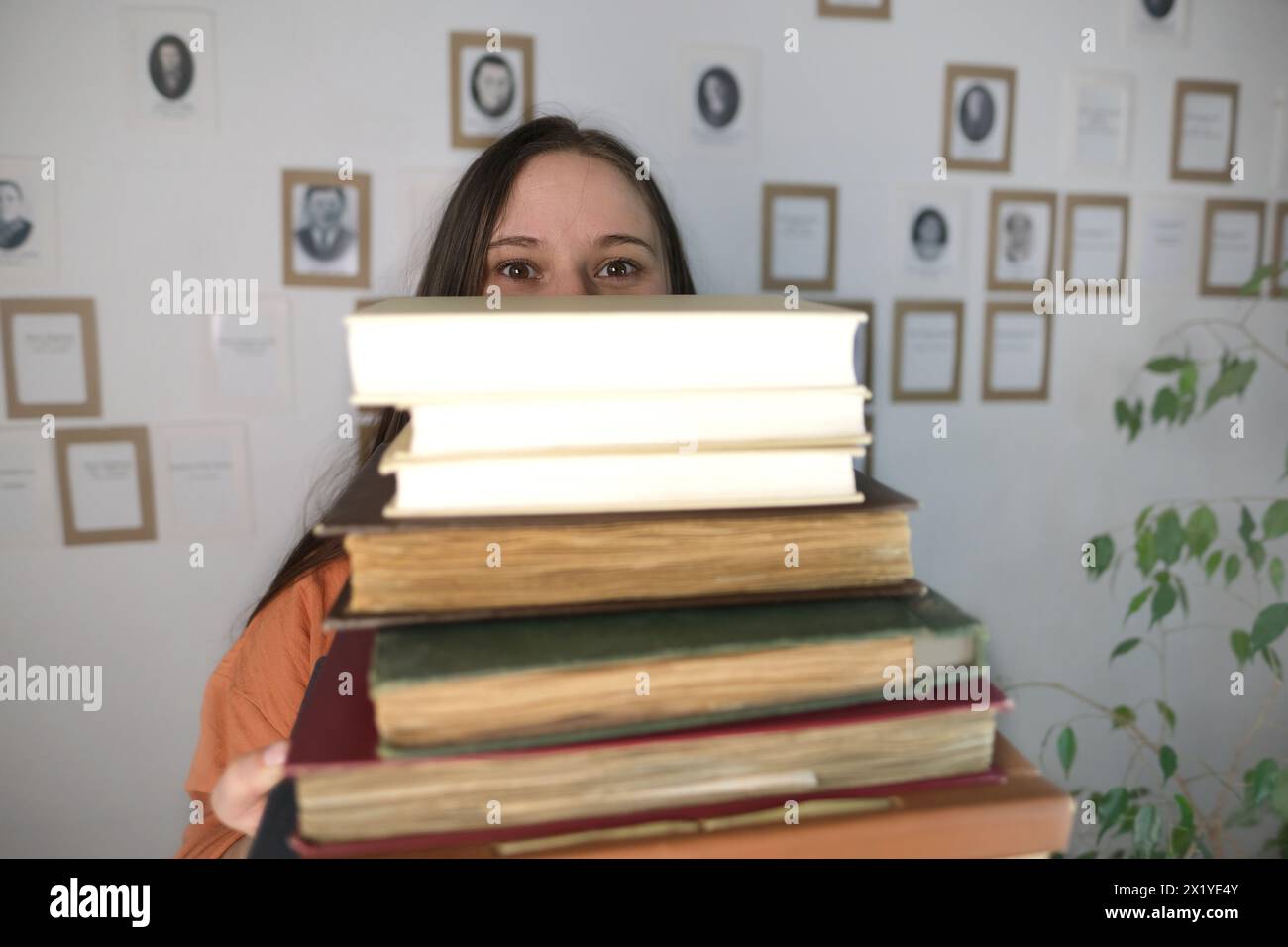 giovane donna europea con capelli lunghi che tiene vecchi e spessi album fotografici, archivio familiare, concetto di genialogia, memoria degli antenati, albero genealogico, infanzia Foto Stock
