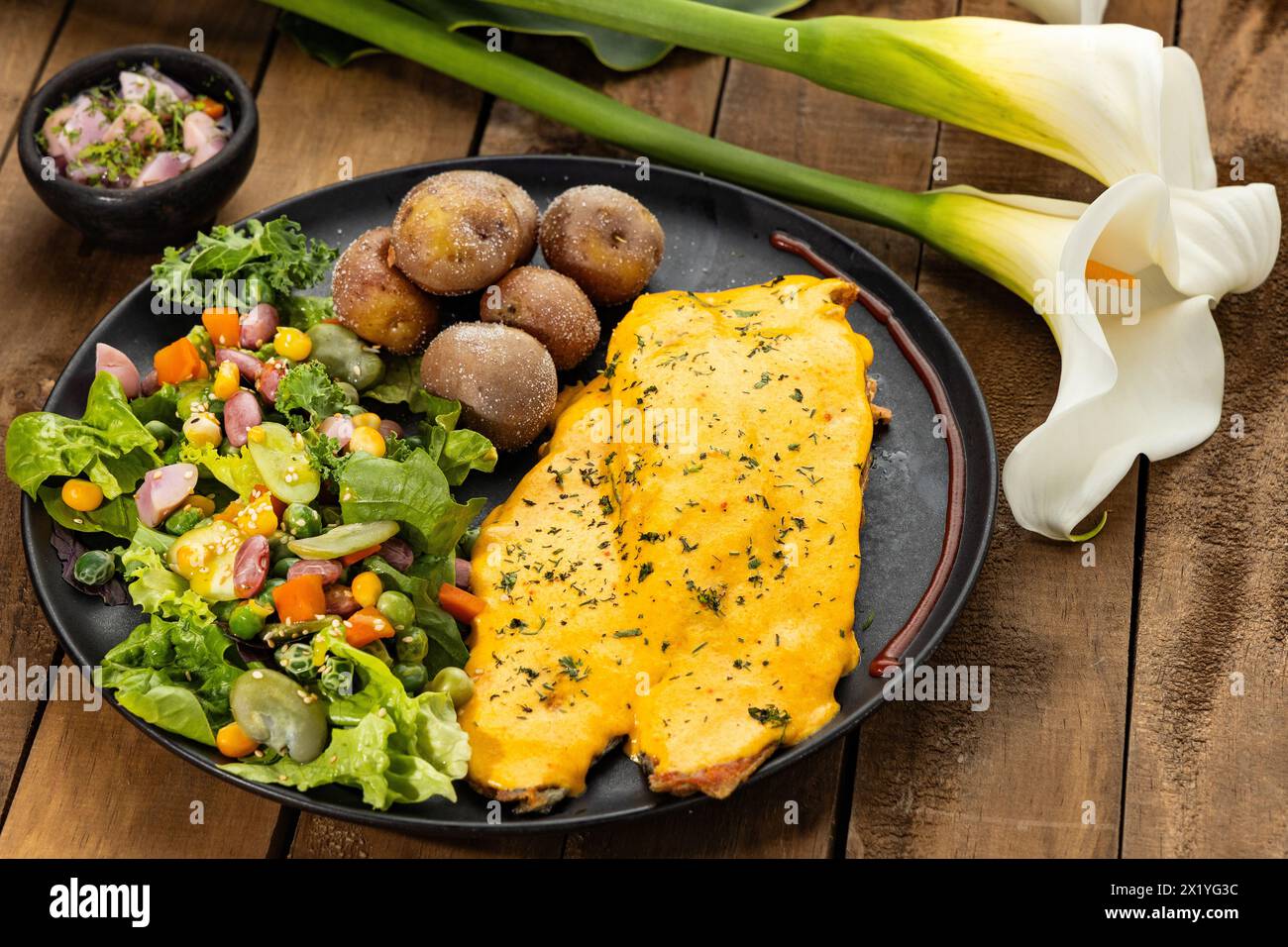 Trota fritta bagnata in salsa di cipolla con insalata e patate al forno Foto Stock