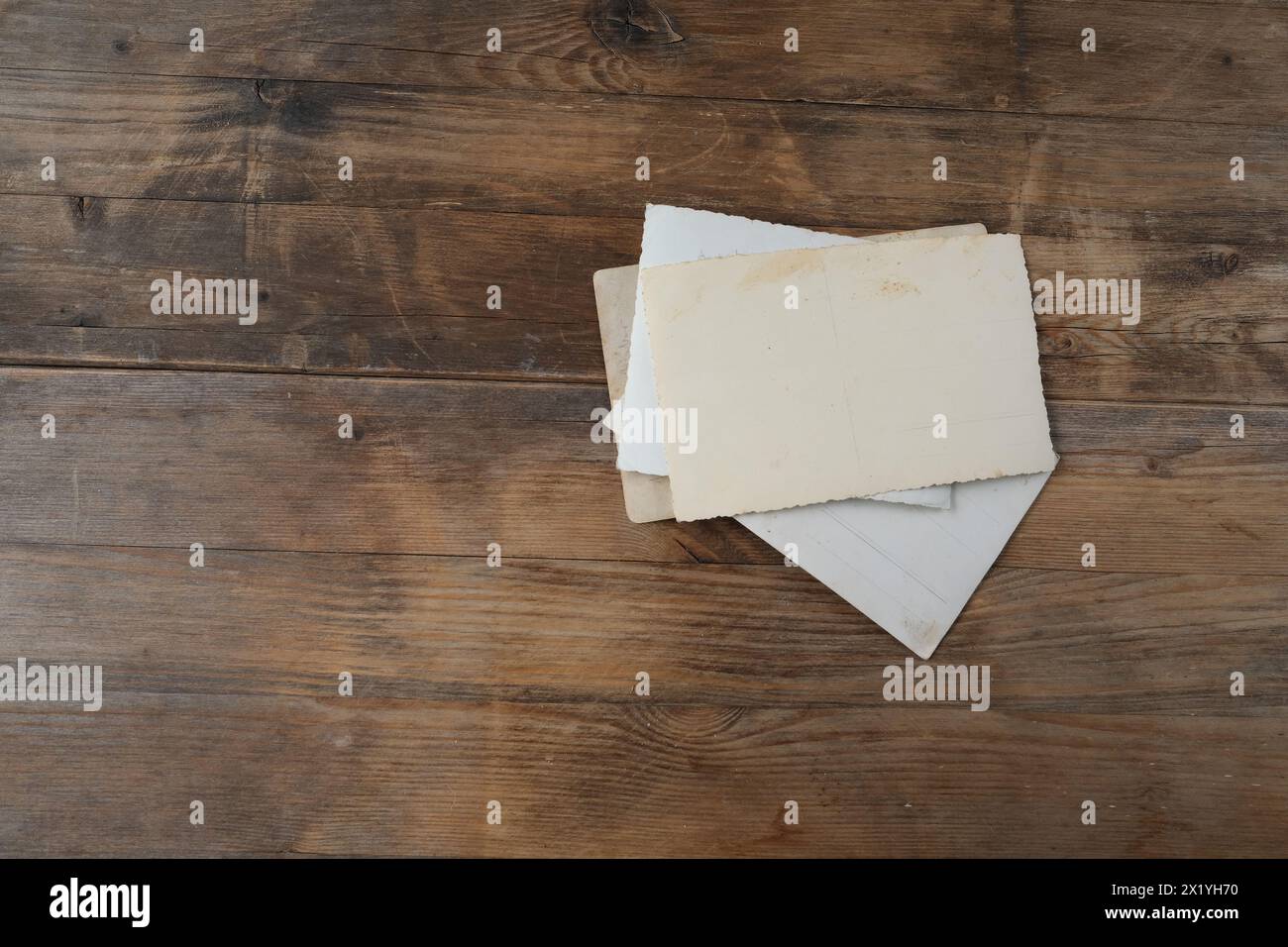 pila di carta vintage con bordo per il lato interno su sfondo in legno naturale, genealogia di famiglia concettuale, ricordi, legami generazionali Foto Stock