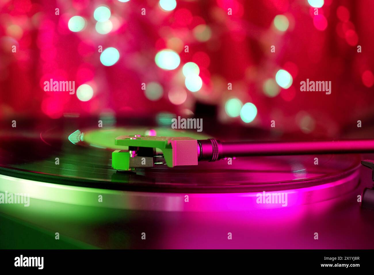 primo piano di un pickup su un disco in vinile, illuminazione a colori, musica retrò analogica, esperienza audio, relax, divertimento musicale, vintag Foto Stock