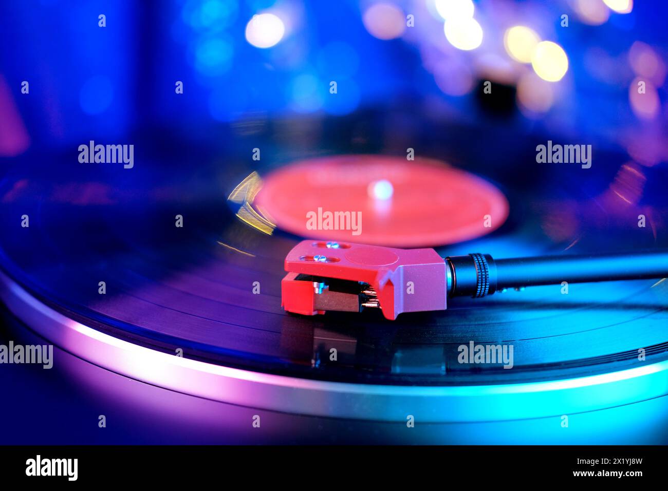 primo piano di un pickup su un disco in vinile, illuminazione a colori, musica retrò analogica, esperienza audio, relax, divertimento musicale, vintag Foto Stock