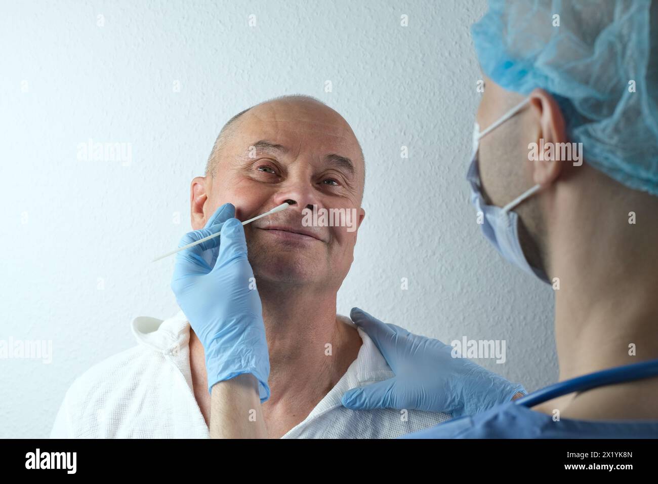 medico maschile in guanti prende con tampone campione dal naso per l'analisi, test nasale rapido covid-19, rilevamento di malattia virale, indagine della polizia, dete Foto Stock