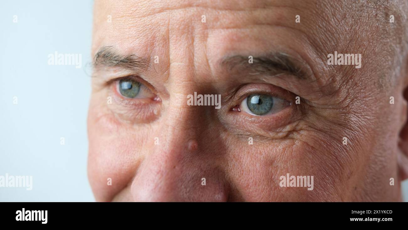 primo piano del volto vecchio, anziano con profonde rughe, allegri occhi grigi ridono, concetto di emozione umana, incontrare la vecchiaia con dignità Foto Stock