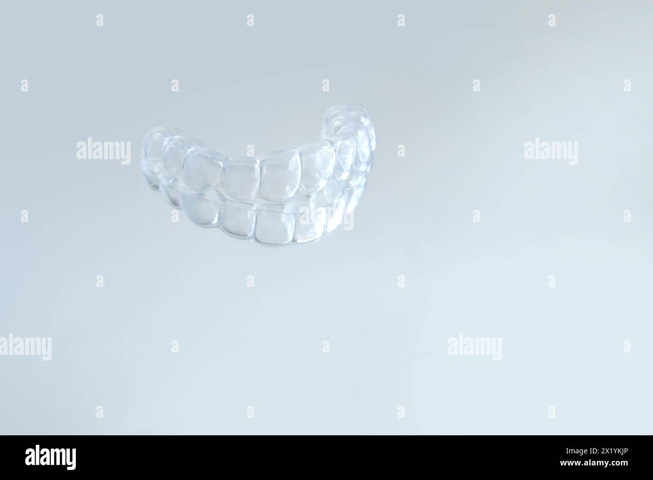 Primo piano di protezione della bocca notturna in silicone trasparente per il fissaggio dei denti smerigliatura dentaria supporto per il sonno, servizi odontoiatrici concettuali, rimedio per la smerigliatura Foto Stock