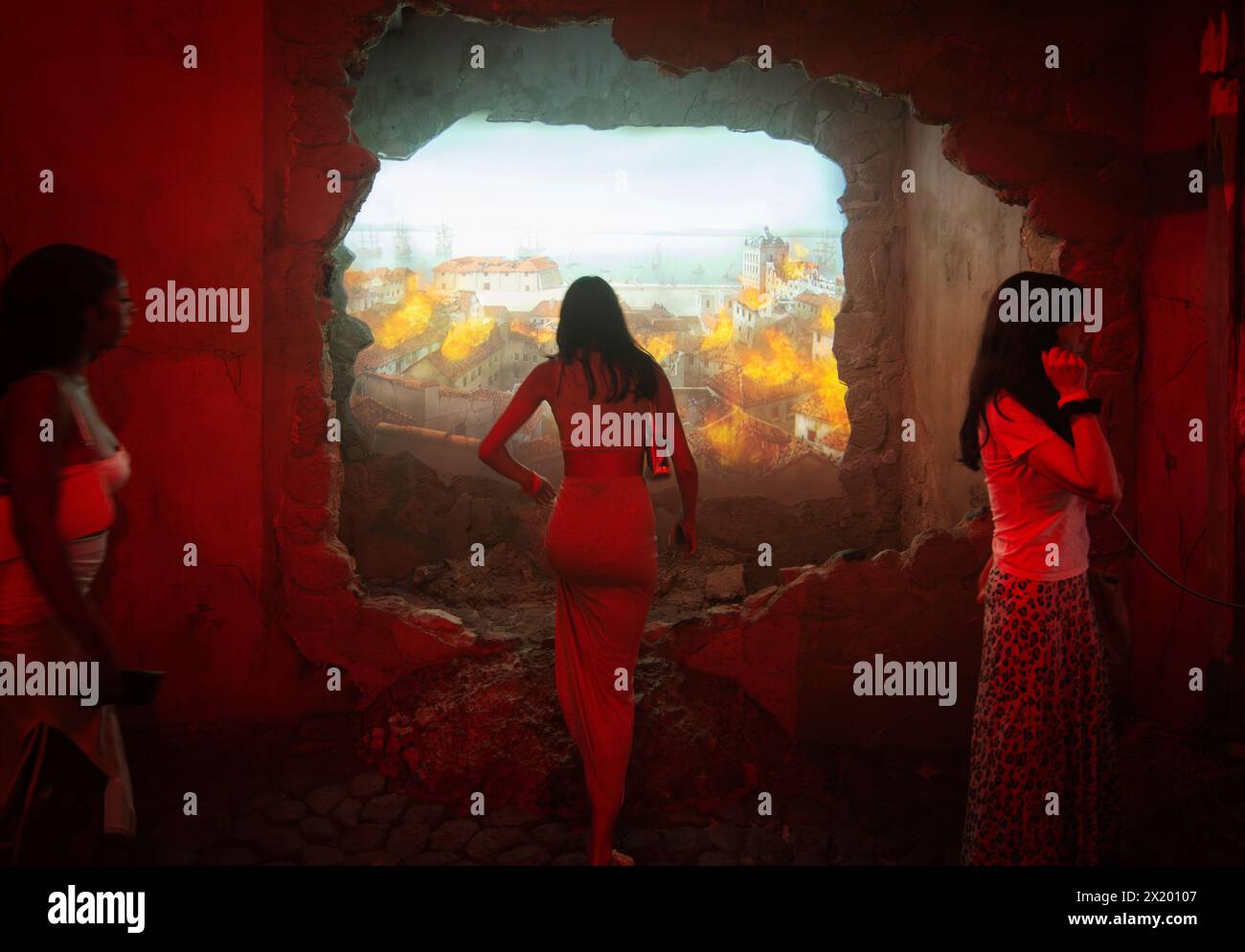 QUAKE Lisbon EARTHQUAKE Museum, Centro do Terramoto De Lisboa, Belém, Lisbona, Portogallo. I visitatori camminano attraverso un vero e proprio vicolo di Lisbona. Una proiezione video dell'incendio dopo il terremoto del 1755 viene proiettata attraverso un modello di un muro distrutto. Il Museo di 1.800 metri quadrati dedicato al grande terremoto di Lisbona del 1755 è stato aperto al pubblico nell'aprile 2022. Foto Stock