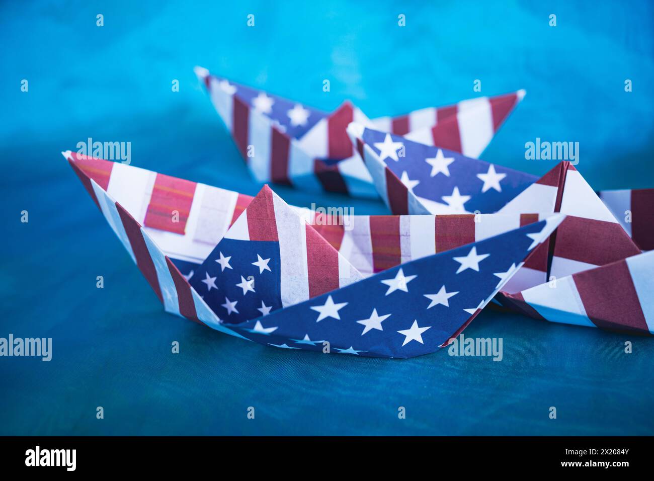 Barca di carta con bandiera americana su sfondo blu. Columbus Day Concept. Foto Stock