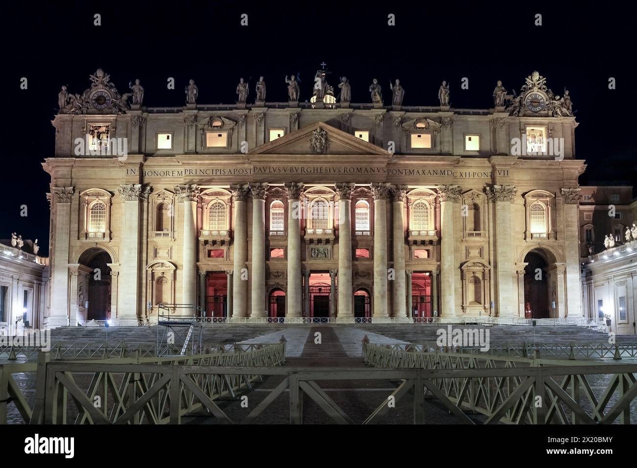 Vista notturna della Basilica di San Pietro nella città del Vaticano, l'enclave papale di Roma, che mette in risalto la sua maestosa sagoma contro il cielo oscurato Foto Stock