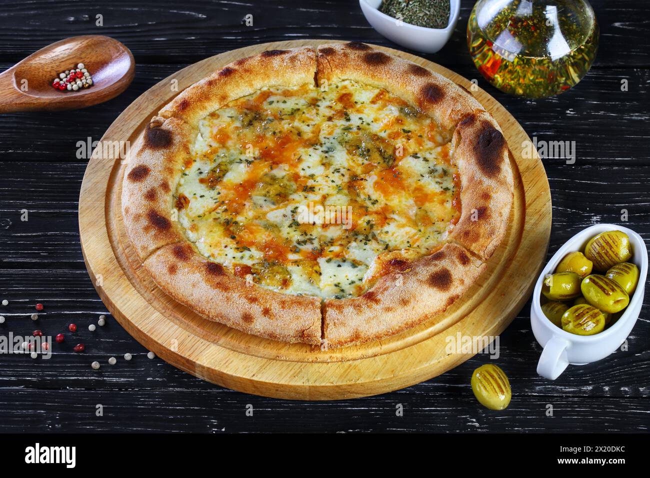 Pizza con funghi, salsicce e olive su sfondo nero Foto Stock