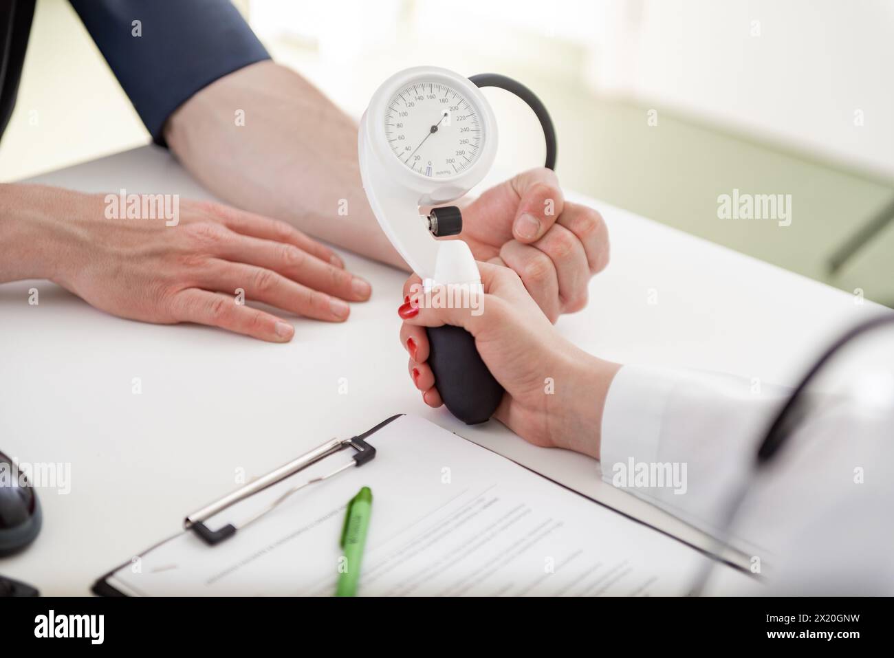 Un esperto medico si concentra sulla scrittura delle informazioni vitali in un ambiente clinico. Foto Stock